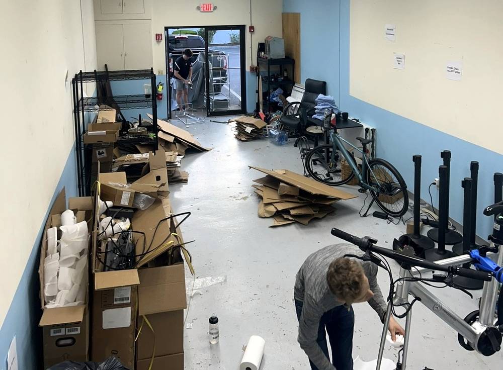 A commercial room packed with cardboard, boxes, shelving and bikes before Junkaroos cleared it out